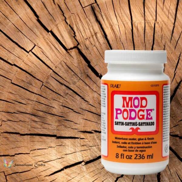Mod Podge Satin 236 ml bottle on a rustic cracked-wood background