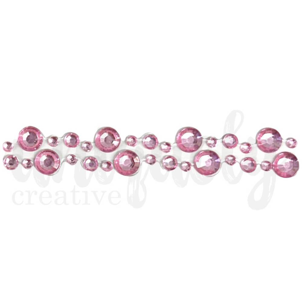 Close-up of pink rhinestone adhesive tape strip with alternating large and small faceted gems in a glossy finish, arranged in parallel rows.